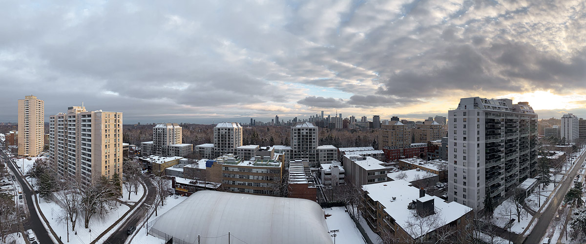 Broken grey cloud with pale gaps and a warm break near the horizon on the right, snow covering the ground and the dome.