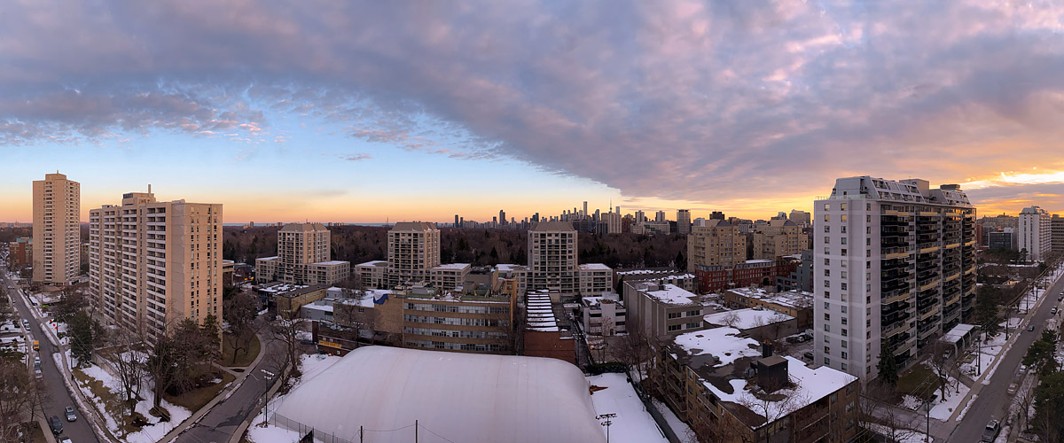 Pink and mauve cloud spreads across the sky above a gold band at the horizon, snow lying below.