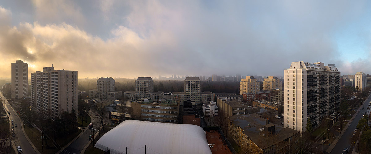 Low mist and cloud lit warm from behind, the skyline barely showing through and the ground bare and wet.