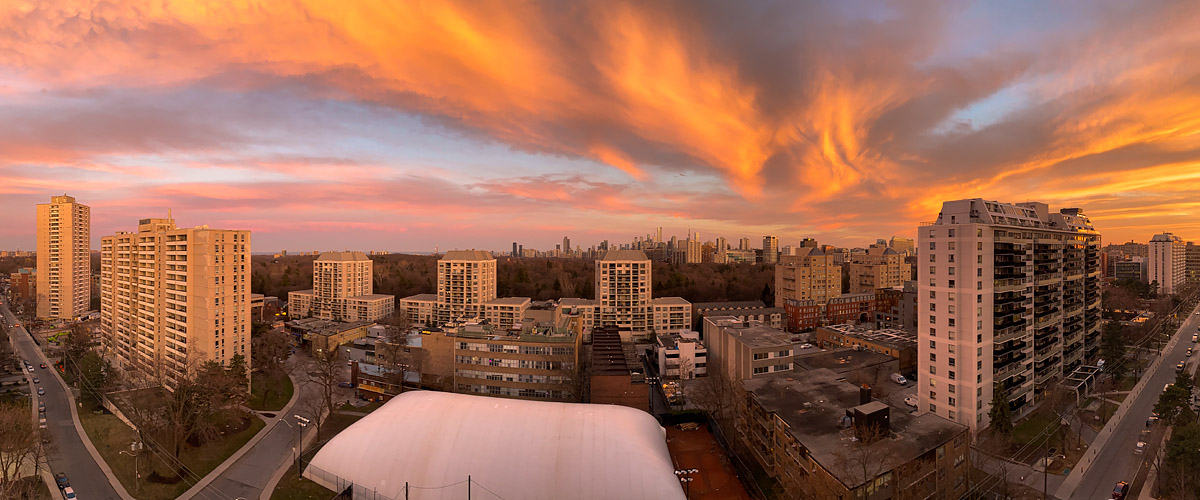 Orange and red fill the whole sky in long streaks above a dark skyline.