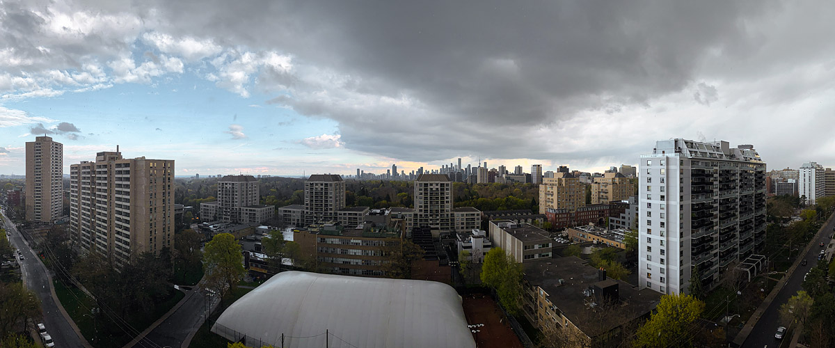 A heavy dark cloud mass covers the right of the sky with a blue break to the left and warm light reaching the skyline.