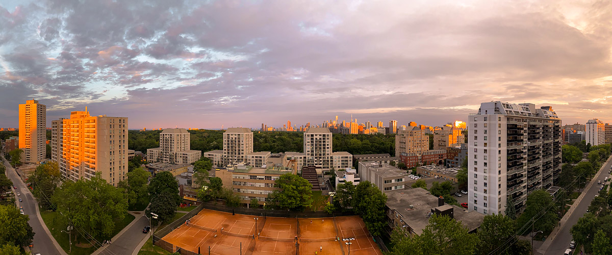 Pink and mauve cloud covers the sky with warm light on the tower faces and the clay courts.