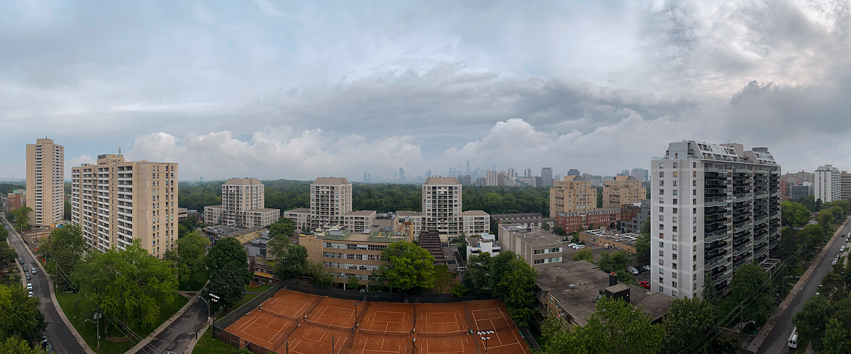 A layered band of grey cloud across the sky with paler gaps above and below, the skyline soft in the distance.