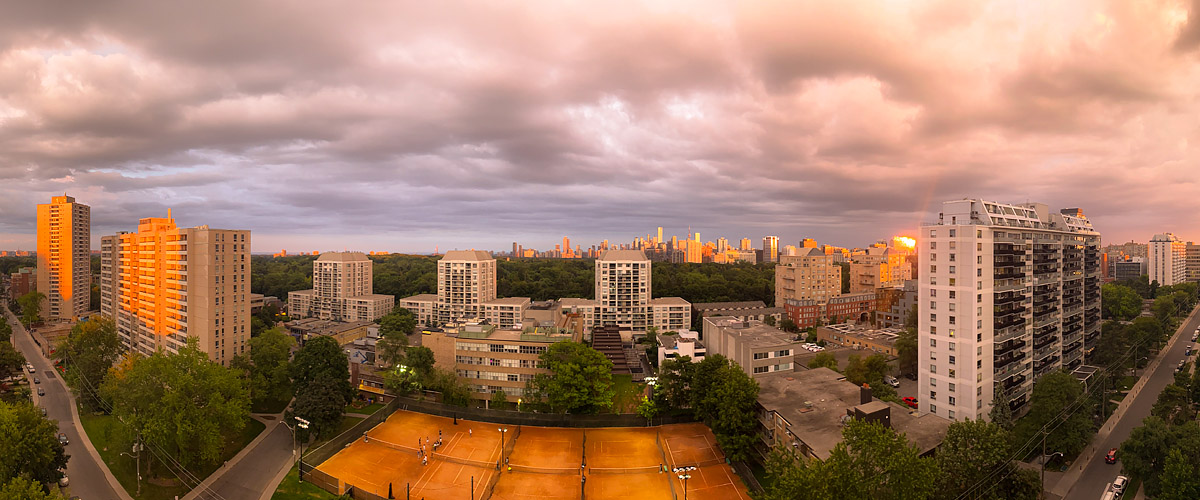 Pink and orange cloud covers the sky with warm light on the tower faces and the clay courts.