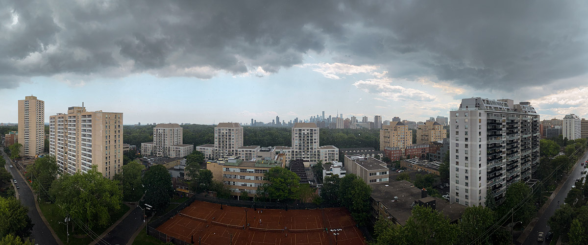 Dark storm cloud fills the sky with a bright pale band along the horizon under its leading edge.