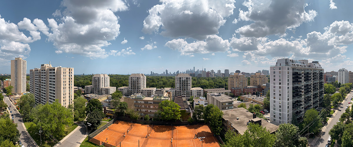 Bright cumulus scattered across a deep blue sky with the skyline sharp and the courts in full sun.