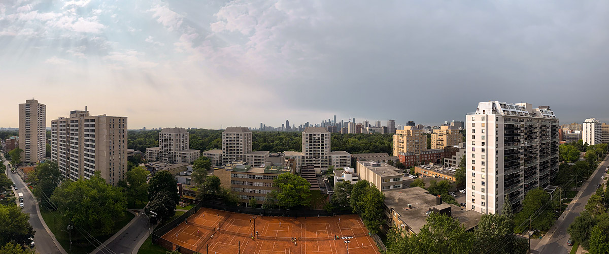 Grey cloud covers the sky with pale light and faint rays to the left, the skyline soft in the distance.