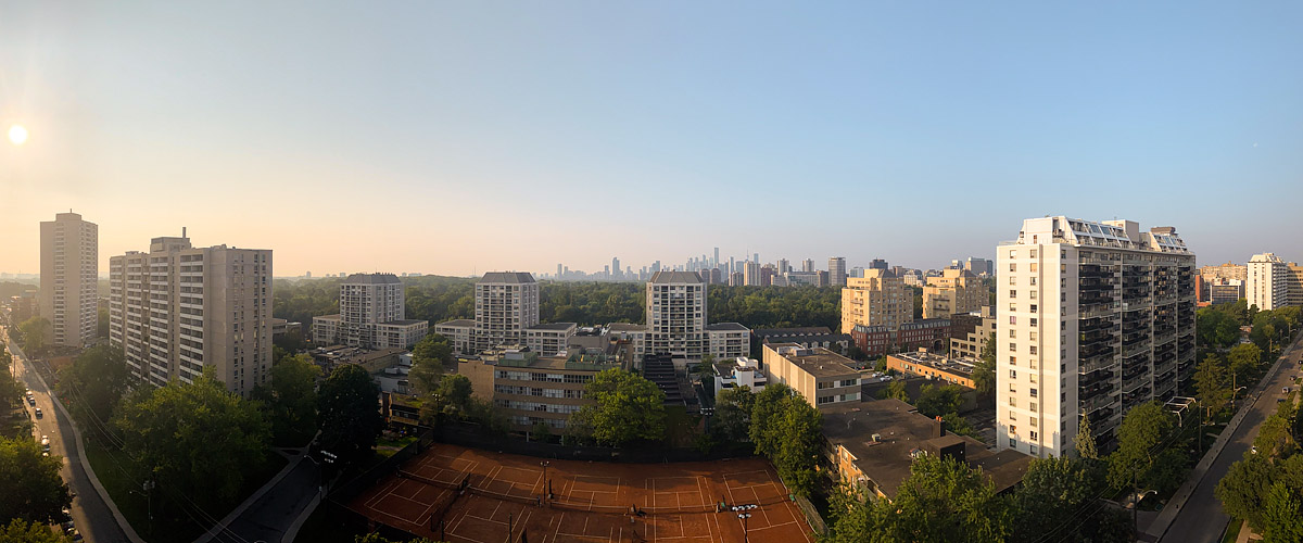 Cloudless sky with the low sun soft on the left and the skyline pale on a hazy horizon.