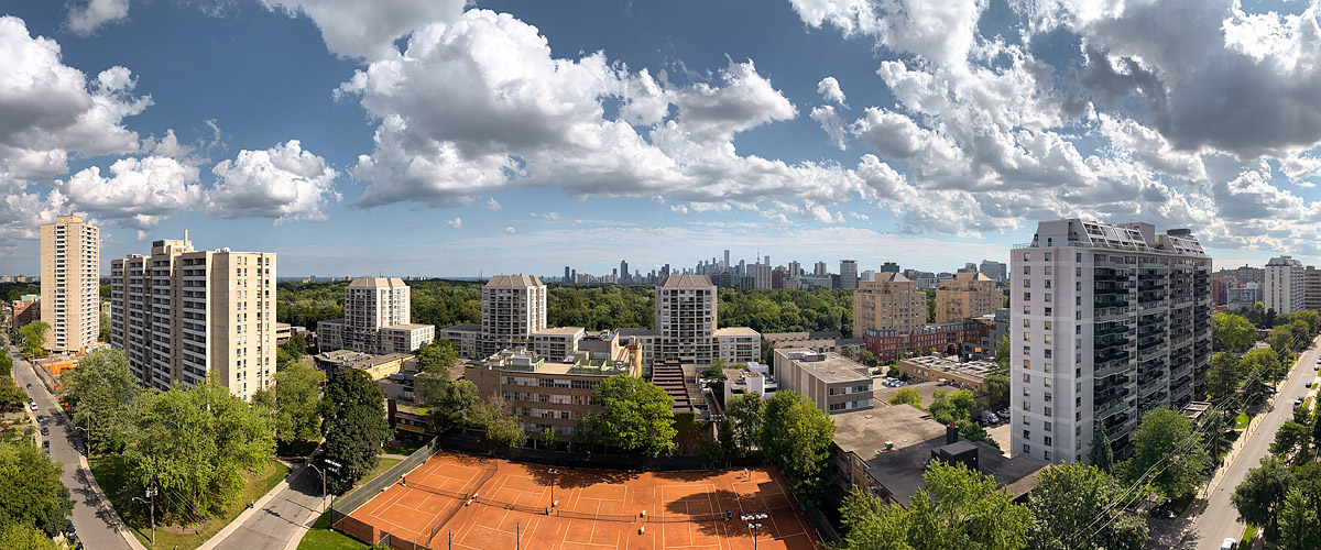 Bright white cumulus across a deep blue sky with the skyline clear and the courts in full sun.