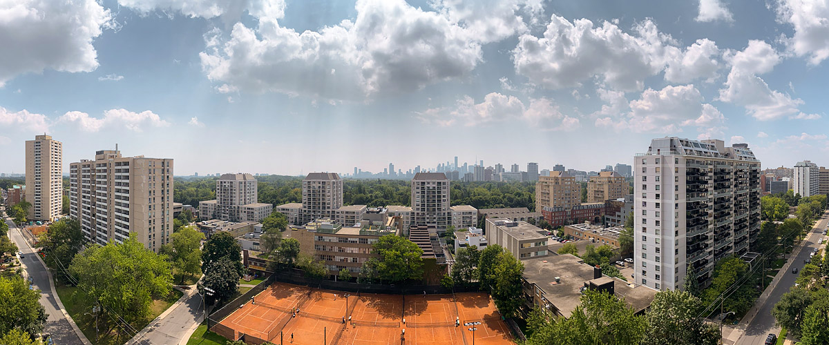Tall cumulus over a blue sky with a hazy horizon and the courts busy below.