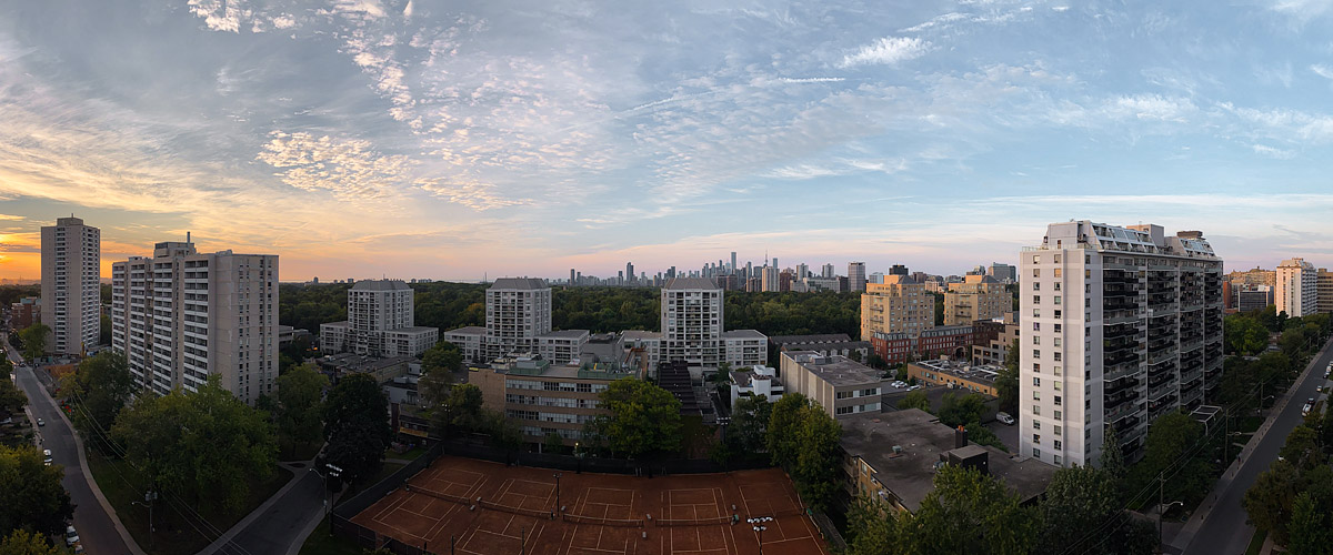 Patchy cloud across a blue sky with gold light on the left and the skyline sharp.