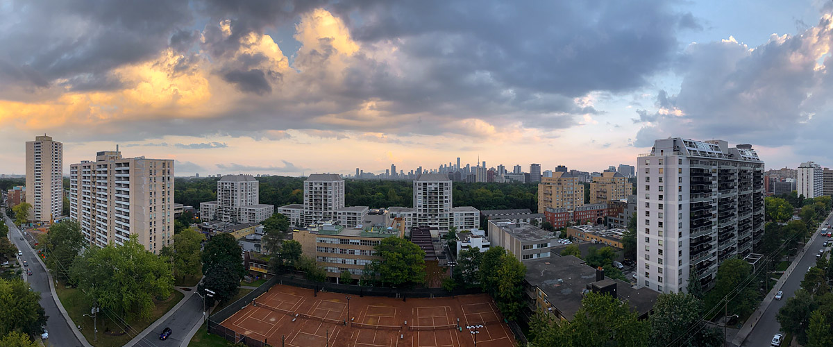 Broken cloud lit gold from beneath with blue gaps above and the skyline clear in the distance.