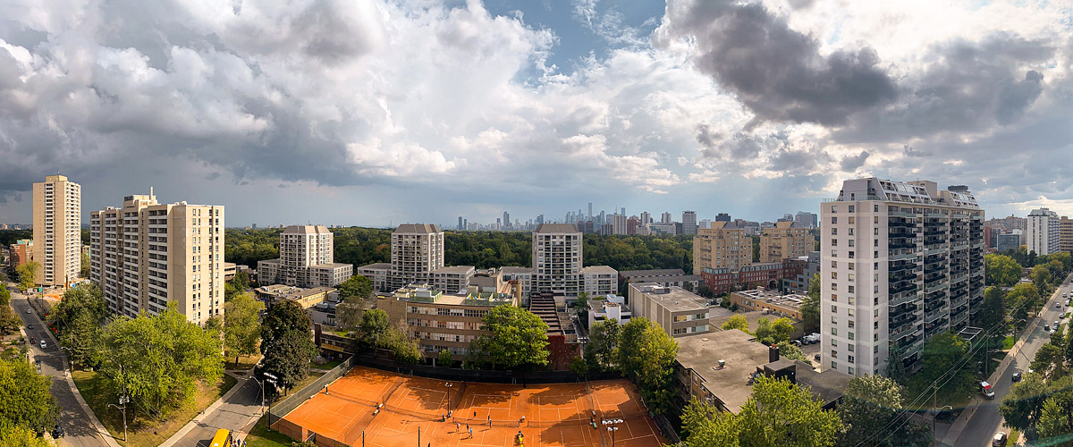 Broken white and grey cloud over blue with the skyline clear and the courts in full sun.