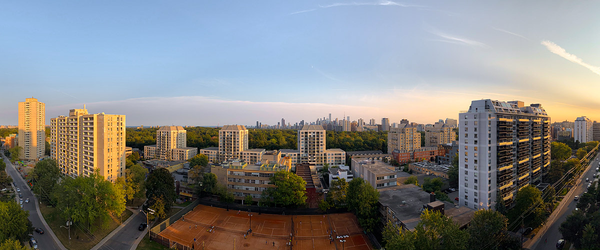 Clear blue sky with a few thin streaks near the horizon and warm light across the frame.
