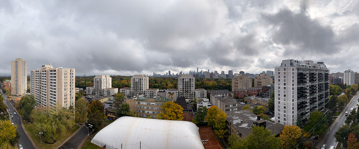 Heavy grey cloud covers the sky in flat light with the skyline legible and autumn colour below.