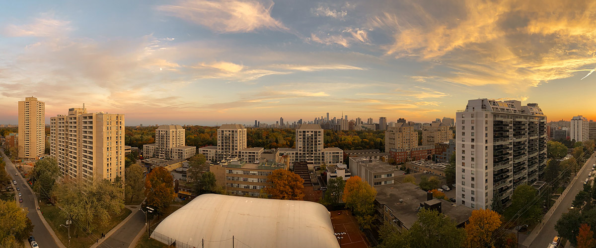 Gold and peach spread across the whole sky in high streaked cloud above a dark skyline.