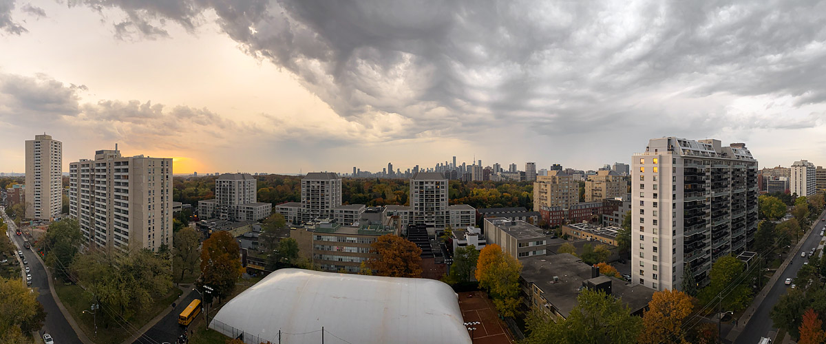 A dark broken cloud mass over most of the sky with a bright gold break at the left horizon.