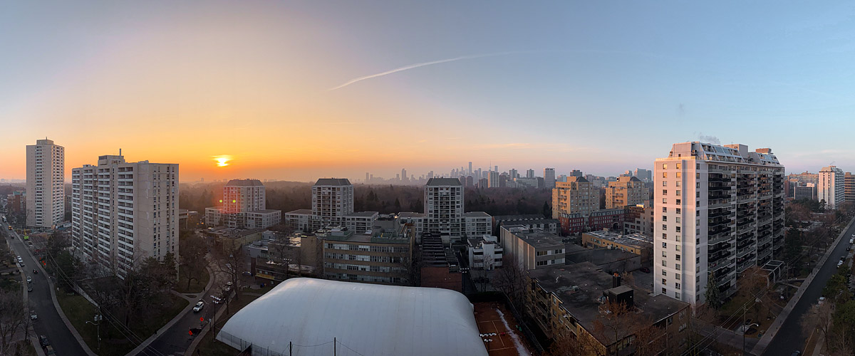 Clear sky with the low sun and a wide gold band along a murky horizon, a strip of snow beside the dome.