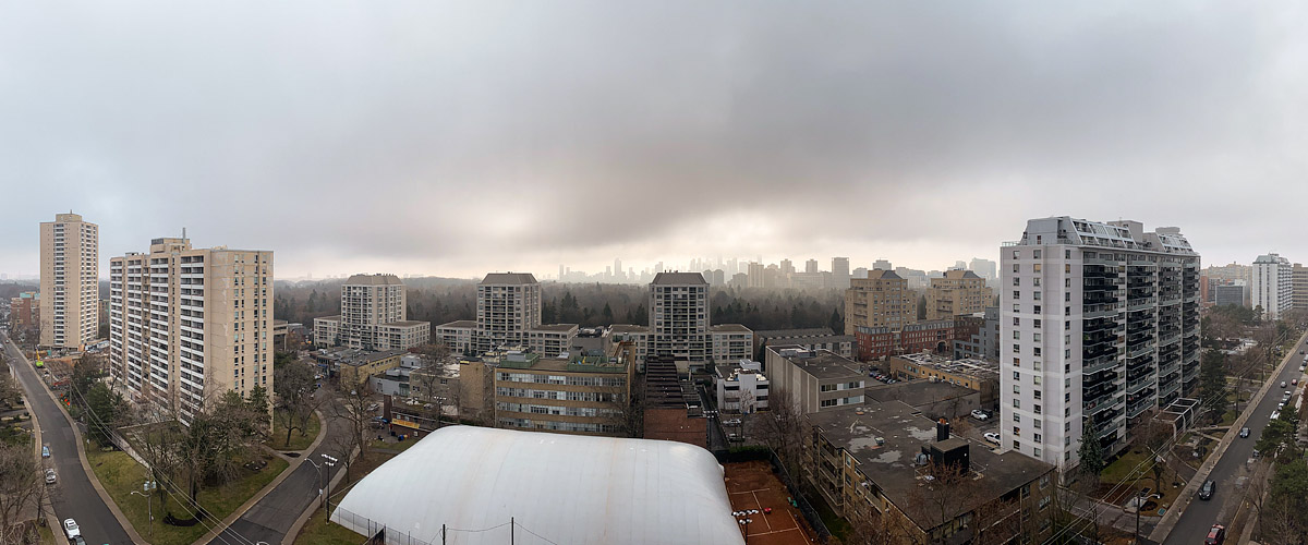 Grey murk and drizzle reduce the skyline to a faint outline with no cloud form visible above.