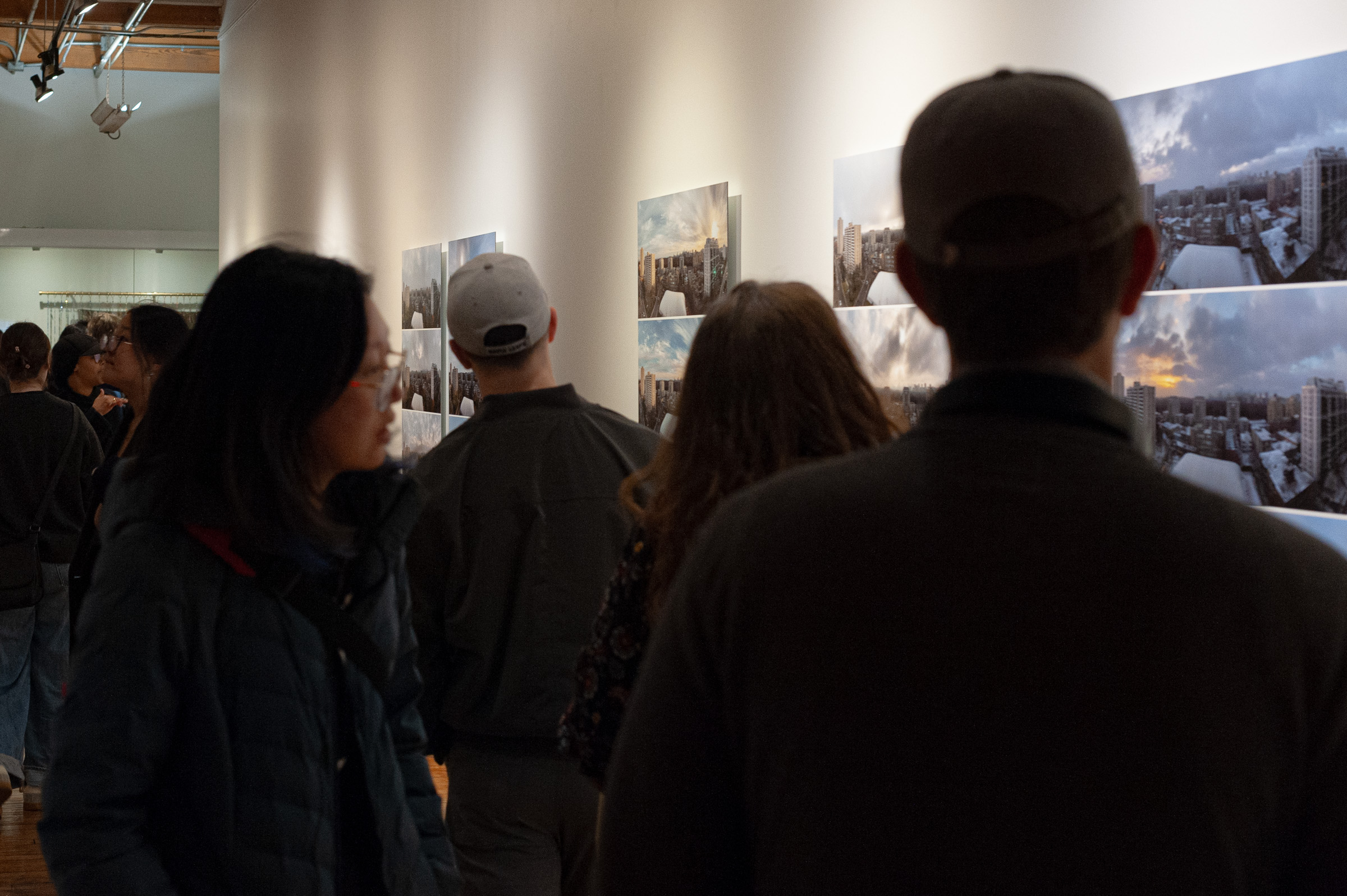 Visitors crowd the corridor in front of the Shifts, seen from behind against the lit wall.
