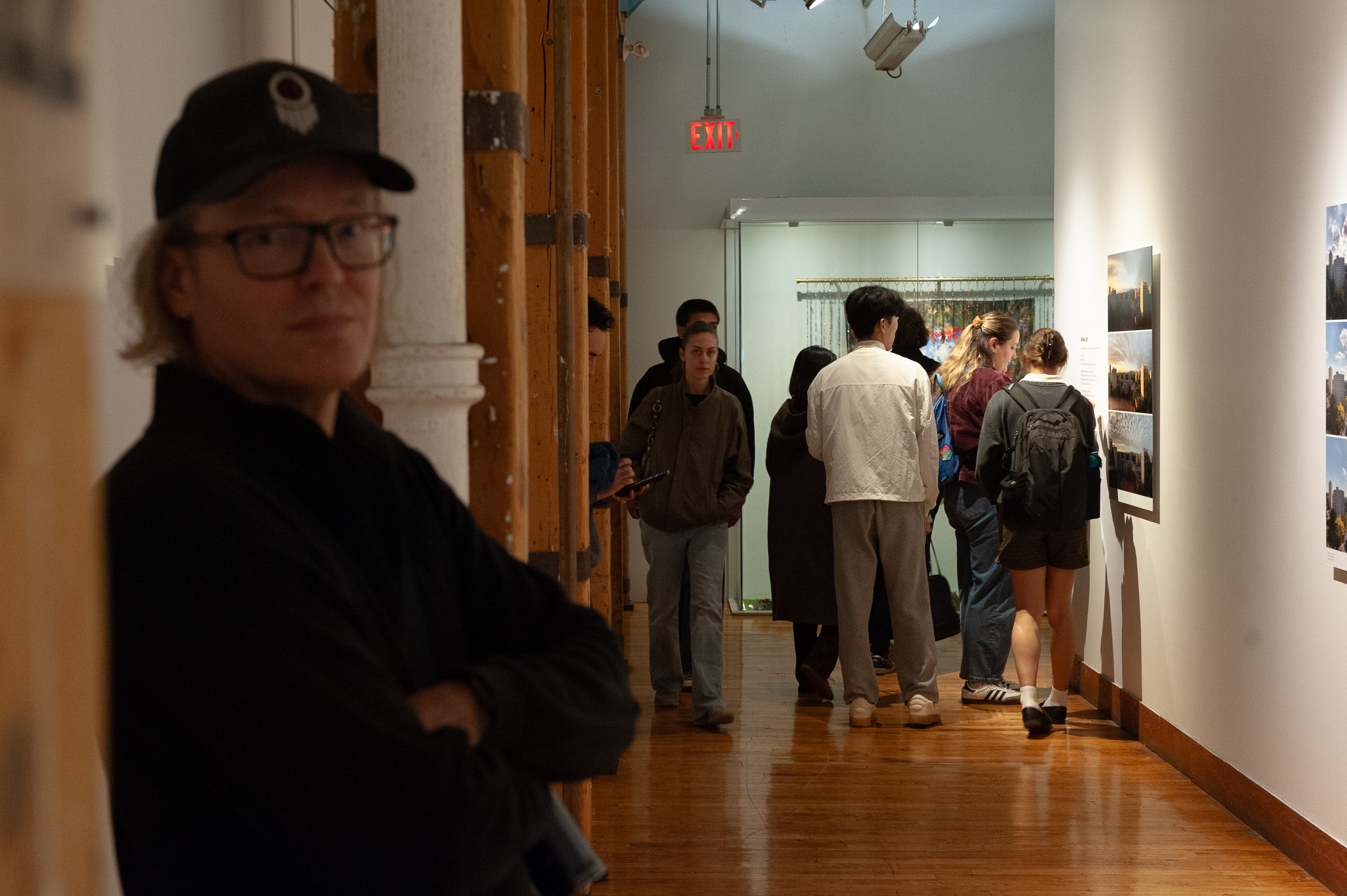Steven Johnson stands in the foreground as visitors fill the corridor behind him.