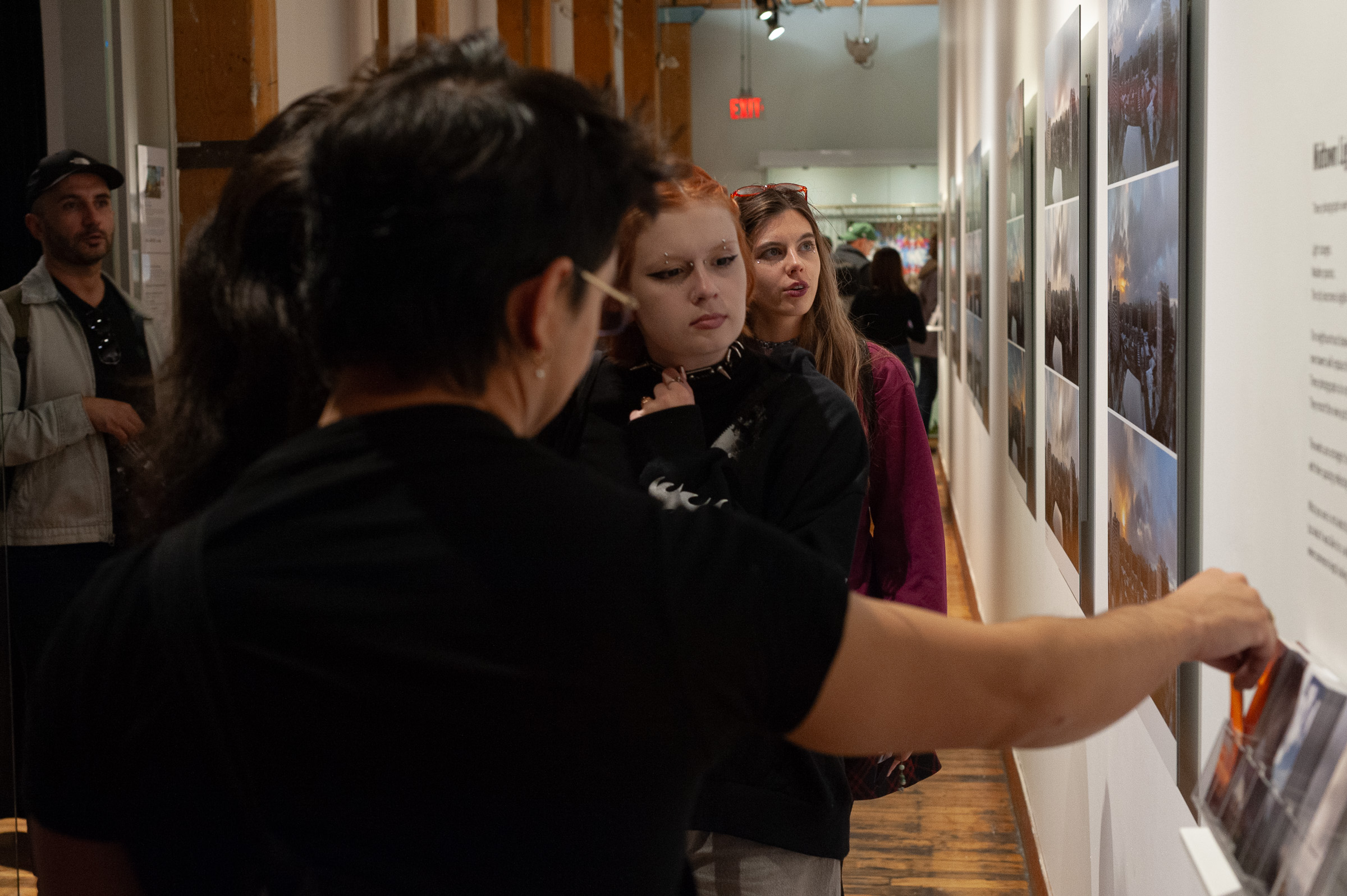 A visitor reaches for the bookmark rack as others look on.